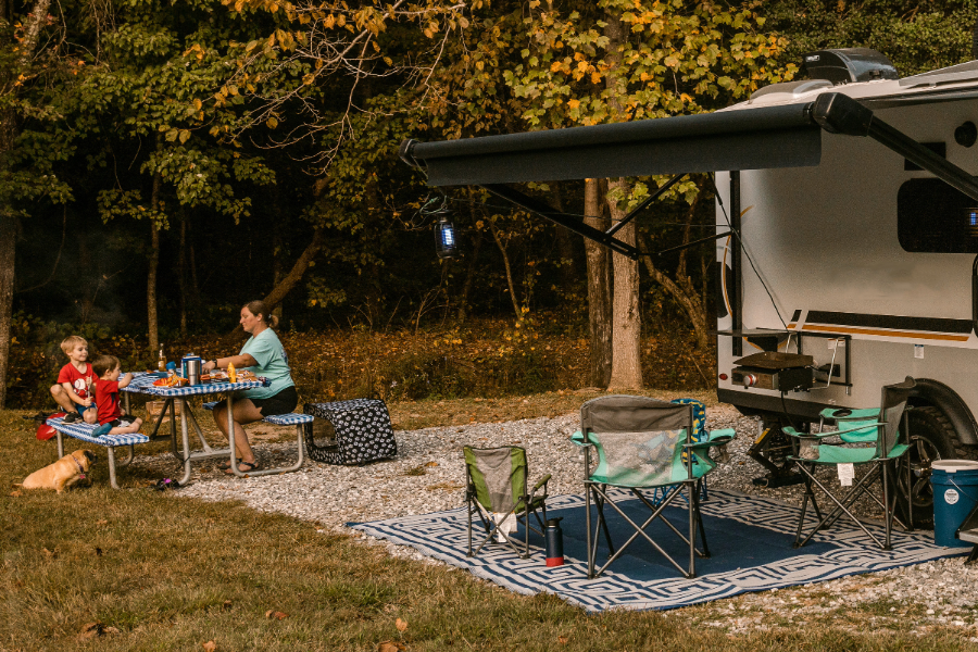 mom and sons eating at picnic table outside of travel trailer