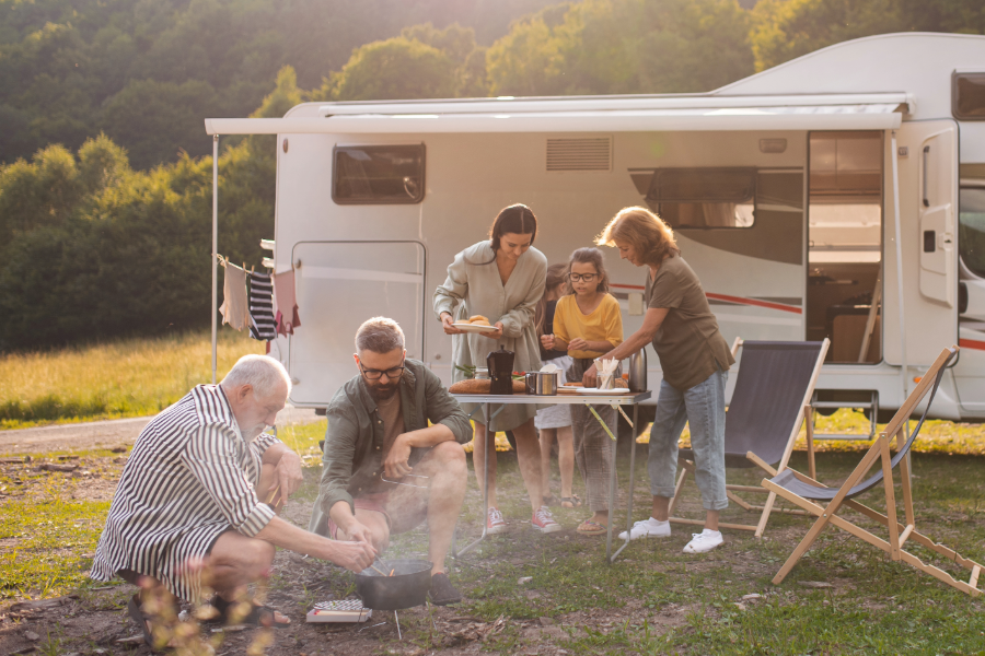 family barbequing outside of motorhome