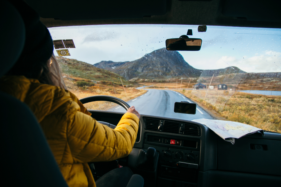 woman driving inside of motorhome in yellow jacket