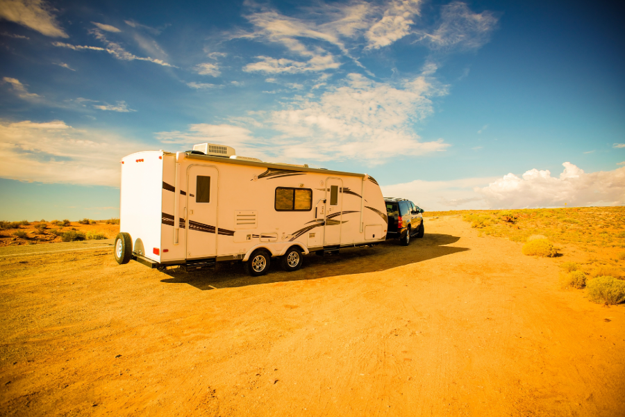 vehicle towing travel trailer in desert