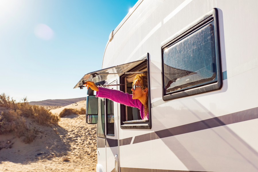 woman looking through open window in motorhome