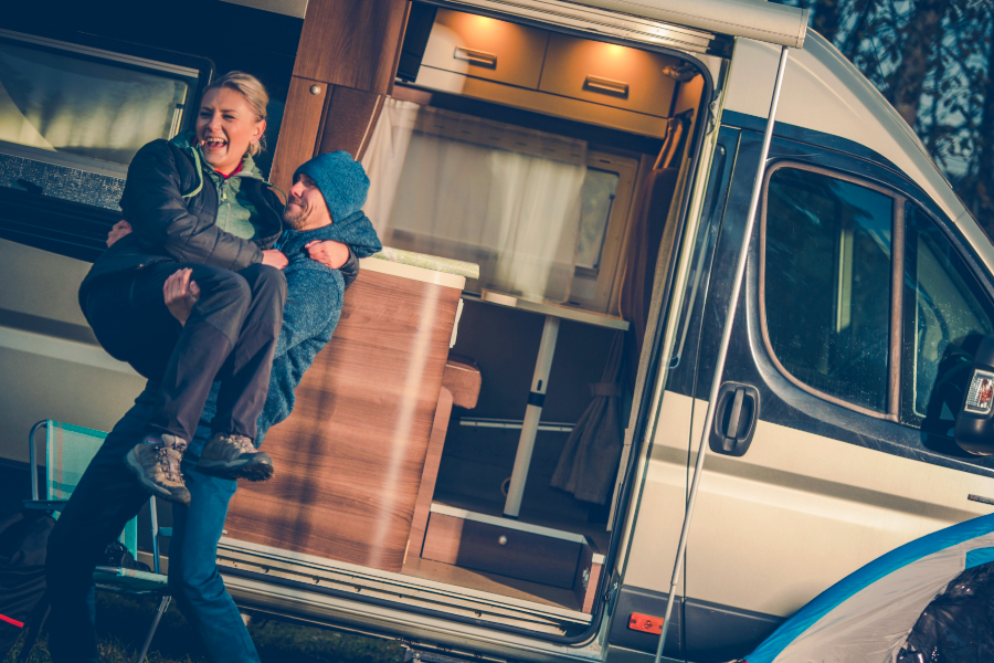 Man holding woman outside of rv