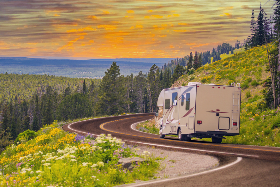 rv driving down winding road with scenic background